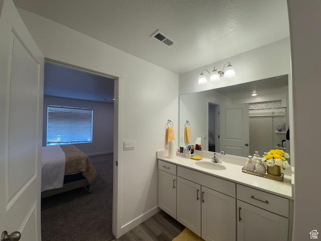 bathroom featuring hardwood / wood-style floors, vanity, and a textured ceiling