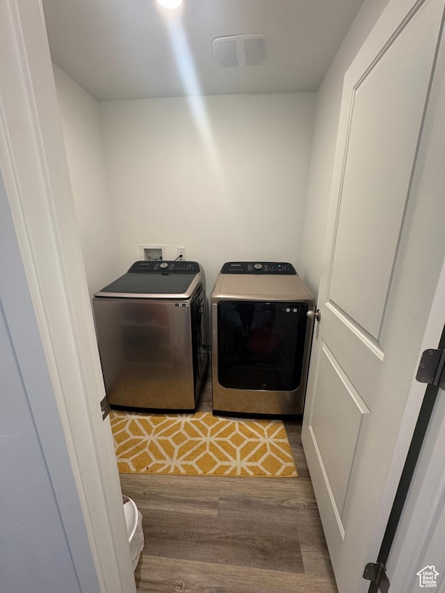 washroom featuring separate washer and dryer and wood-type flooring
