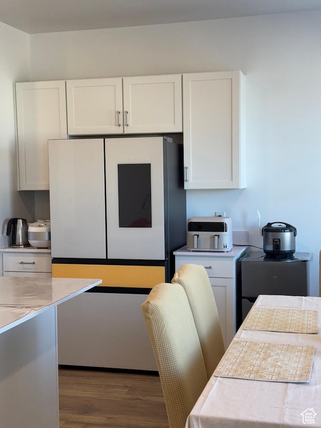 kitchen featuring dark hardwood / wood-style floors, white refrigerator, and white cabinetry