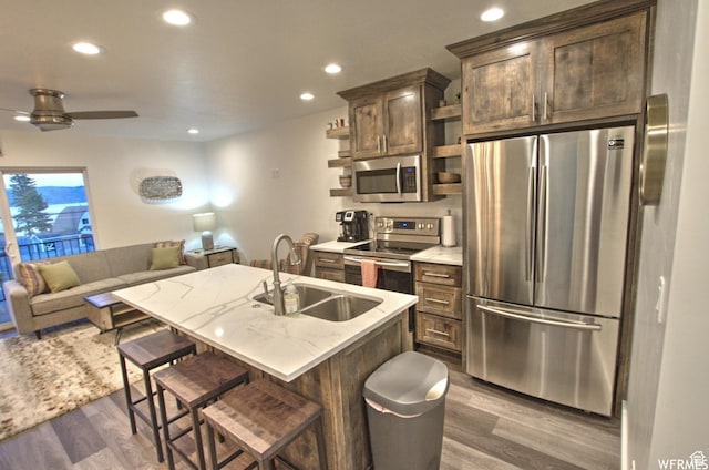 55 W Buttercup Ln Unit 33, Garden City, UT 84028 - kitchen with sink, dark wood-type flooring, a kitchen breakfast bar, an island with sink, and appliances with stainless steel finishes