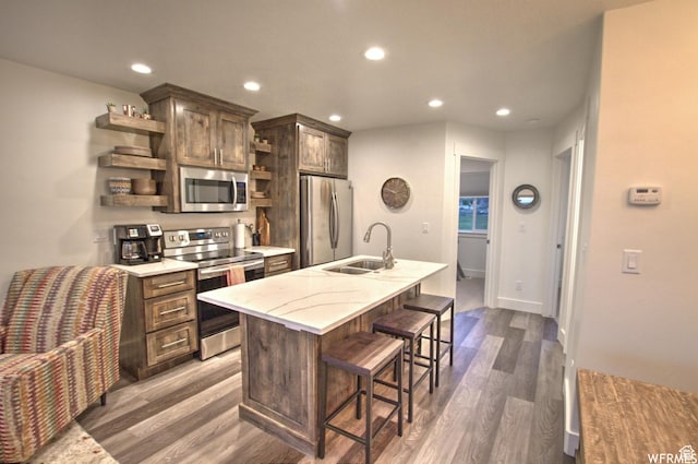 55 W Buttercup Ln Unit 33, Garden City, UT 84028 - kitchen with a kitchen bar, a kitchen island with sink, sink, appliances with stainless steel finishes, and dark hardwood / wood-style flooring