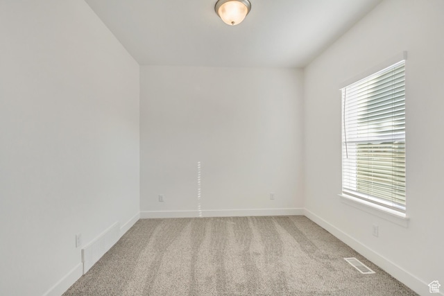 carpeted spare room featuring plenty of natural light
