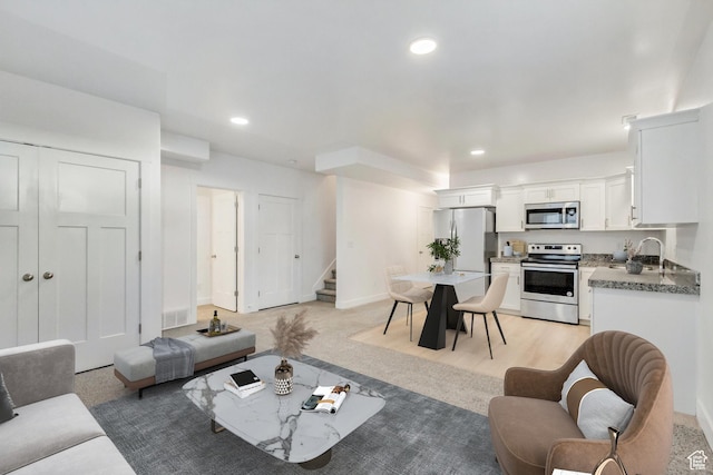 living room with light colored carpet and sink
