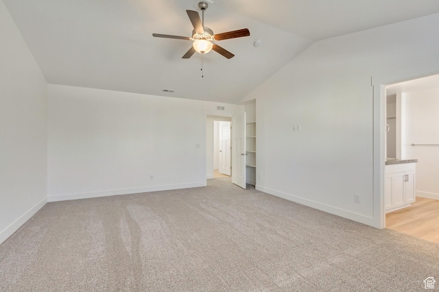 carpeted empty room with ceiling fan and lofted ceiling