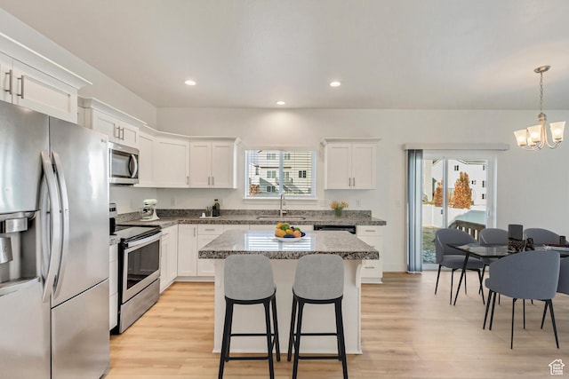 kitchen with a healthy amount of sunlight, sink, white cabinets, and stainless steel appliances