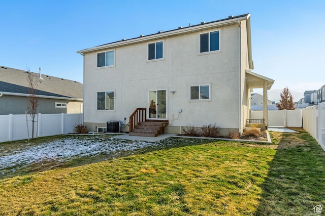 back of house featuring a lawn and central AC