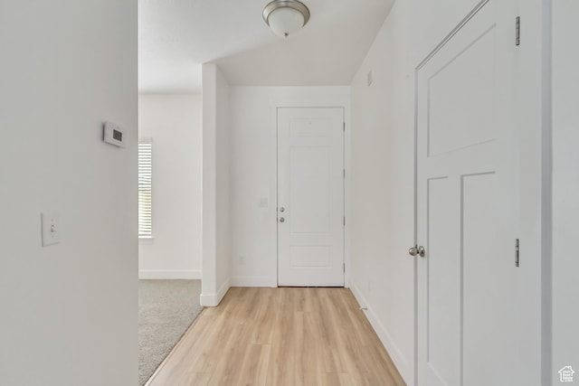 hallway with light hardwood / wood-style floors
