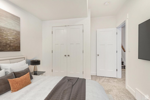 bedroom featuring light colored carpet and a closet