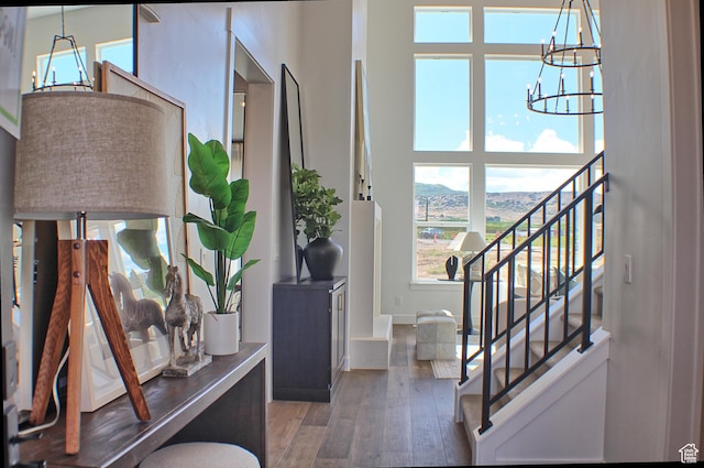 entrance foyer featuring stairway, baseboards, a notable chandelier, and hardwood / wood-style flooring