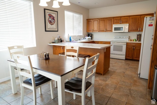 715 Lobo Ln, Washington, UT 84780 - kitchen featuring kitchen peninsula, sink, hanging light fixtures, and white appliances