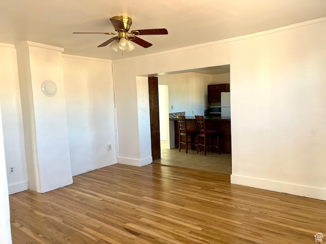 spare room featuring ceiling fan, light hardwood / wood-style floors, and crown molding