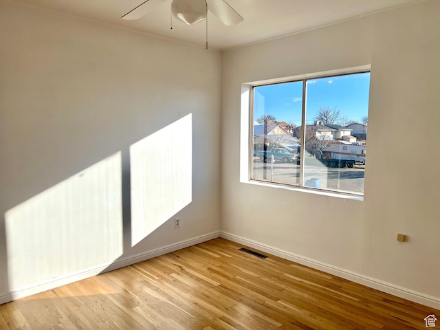 spare room with light wood-type flooring and ceiling fan