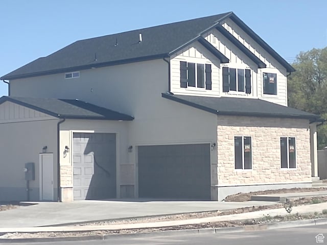 7497 W Sage Slope Way, Herriman, UT 84096 - view of front of property featuring stone siding, a garage, stucco siding, and board and batten siding