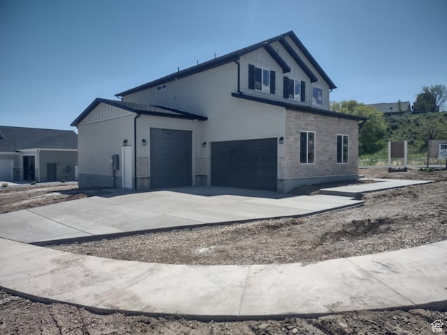 7497 W Sage Slope Way, Herriman, UT 84096 - view of home's exterior featuring stone siding, concrete driveway, and a garage