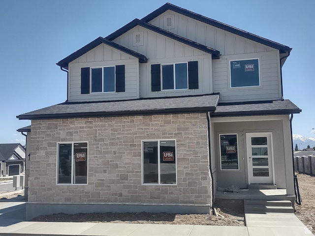 7497 W Sage Slope Way, Herriman, UT 84096 - rear view of property featuring board and batten siding, roof with shingles, and stone siding