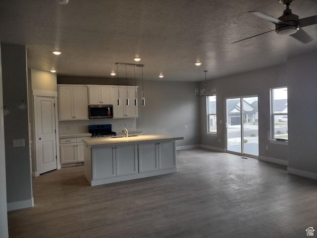 7497 W Sage Slope Way, Herriman, UT 84096 - kitchen featuring stainless steel microwave, stove, baseboards, white cabinetry, and recessed lighting