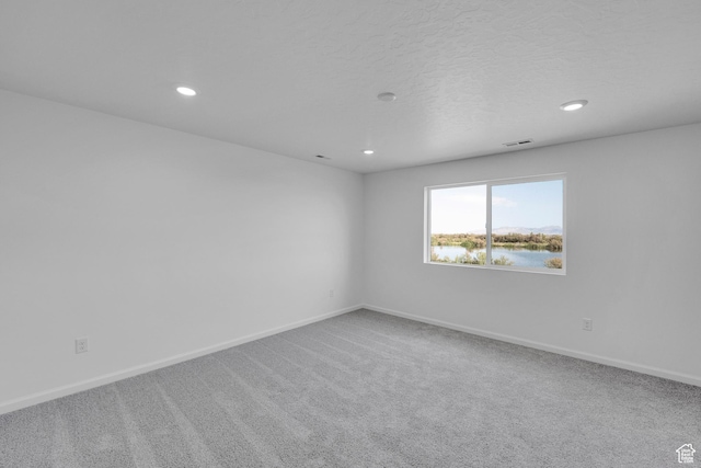 458 W Lefty Ln Unit 1129, Stansbury Park, UT 84074 - spare room with recessed lighting, carpet, baseboards, a water view, and a textured ceiling