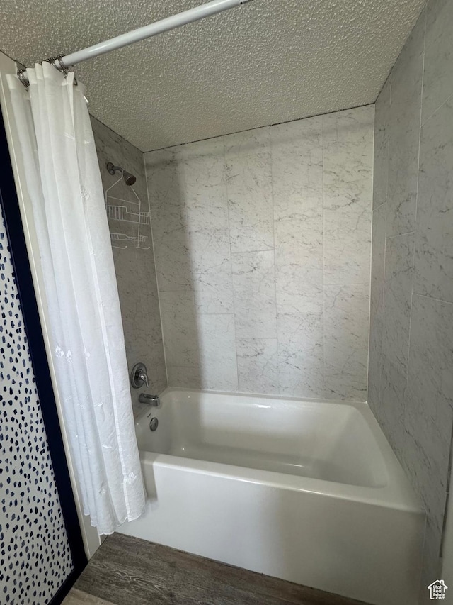 972 E Ridgeway Loop Unit 228, Garden City, UT 84028 - bathroom with shower / bath combo with shower curtain, a textured ceiling, and wood finished floors