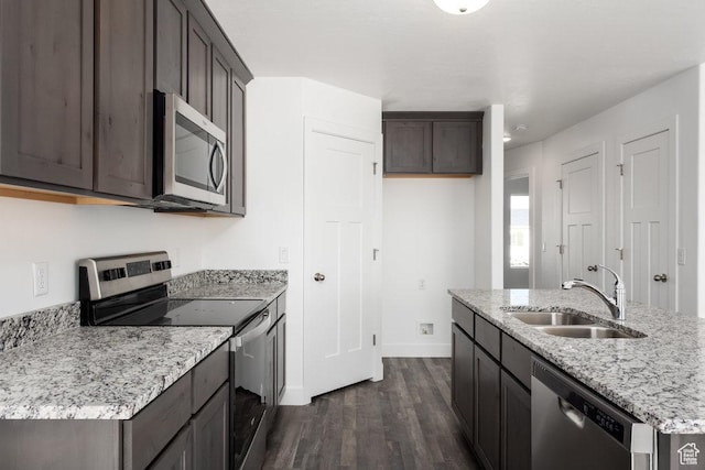 1151 W High Plains Dr Unit 605, Grantsville, UT 84029 - kitchen with appliances with stainless steel finishes, dark hardwood / wood-style flooring, light stone counters, sink, and an island with sink