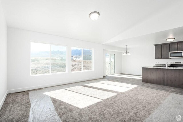 1151 W High Plains Dr Unit 605, Grantsville, UT 84029 - unfurnished living room featuring an inviting chandelier, carpet floors, sink, and vaulted ceiling