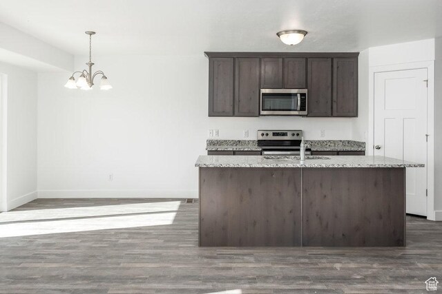 1151 W High Plains Dr Unit 605, Grantsville, UT 84029 - kitchen featuring hanging light fixtures, light stone countertops, appliances with stainless steel finishes, dark hardwood / wood-style flooring, and dark brown cabinetry