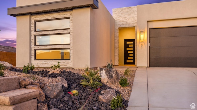 741 S 1800 W, Hurricane, UT 84737 - view of front of home featuring concrete driveway, stone siding, an attached garage, and stucco siding