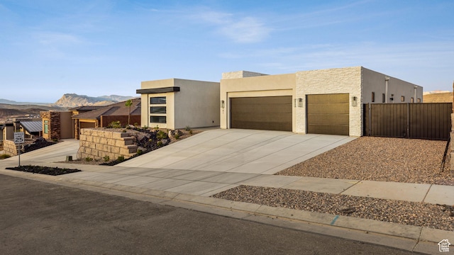 741 S 1800 W, Hurricane, UT 84737 - modern home featuring stucco siding, fence, a mountain view, concrete driveway, and an attached garage