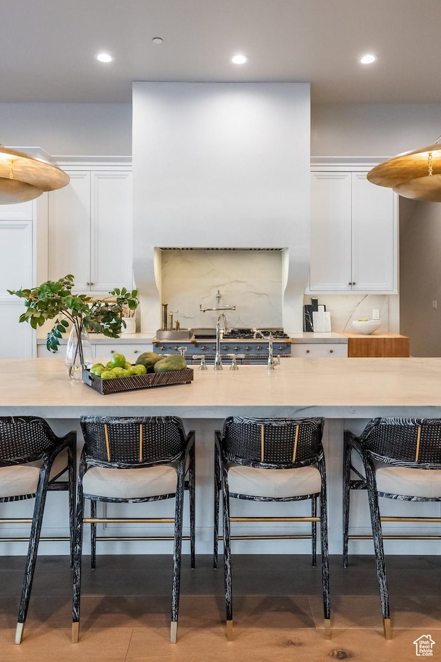 1515 E Bluff Point Dr, Draper, UT 84020 - kitchen featuring white cabinets, light countertops, a kitchen breakfast bar, recessed lighting, and backsplash
