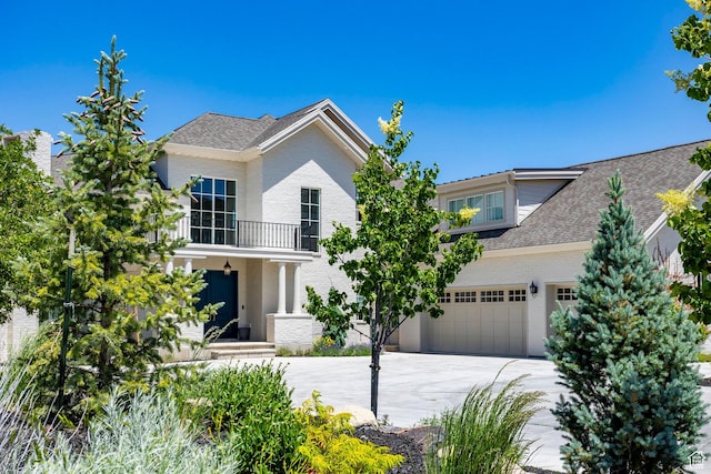 1515 E Bluff Point Dr, Draper, UT 84020 - view of front of house featuring a balcony, concrete driveway, brick siding, and roof with shingles