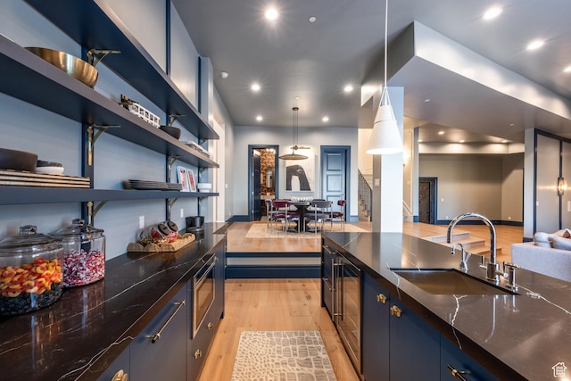 1515 E Bluff Point Dr, Draper, UT 84020 - kitchen featuring light wood finished floors, open floor plan, stainless steel microwave, dark stone countertops, and recessed lighting
