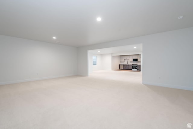 unfurnished living room featuring light carpet
