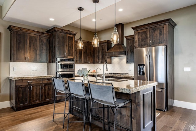 1773 E Longview Dr, Hideout, UT 84036 - kitchen with hardwood / wood-style floors, dark brown cabinetry, stainless steel appliances, and a kitchen island with sink