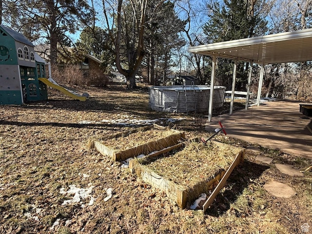 view of yard featuring a garden and a playground