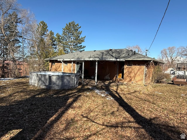 back of house featuring brick siding and a fenced in pool