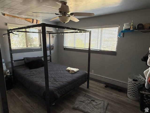 bedroom featuring a baseboard heating unit, ceiling fan, and wood finished floors