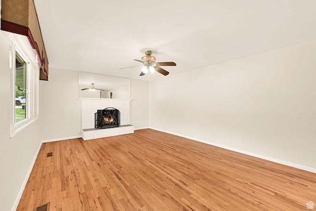 967 E 2800 N, North Ogden, UT 84414 - unfurnished living room featuring a brick fireplace, baseboards, light wood-style floors, and ceiling fan
