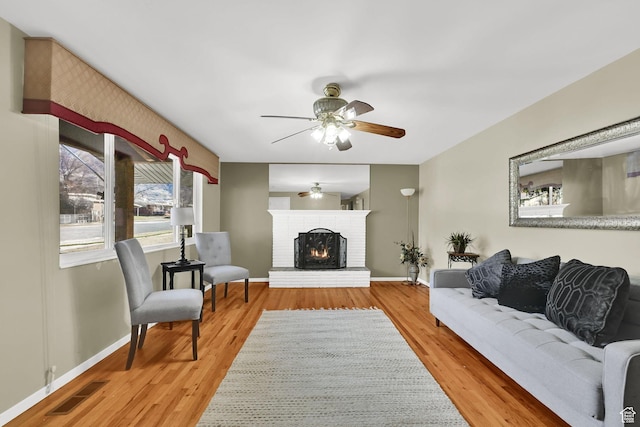 967 E 2800 N, North Ogden, UT 84414 - living area featuring a ceiling fan, a fireplace, wood finished floors, baseboards, and visible vents