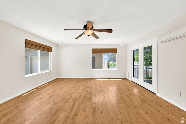 967 E 2800 N, North Ogden, UT 84414 - spare room featuring baseboards, a ceiling fan, a wall mounted AC, and light wood-style floors