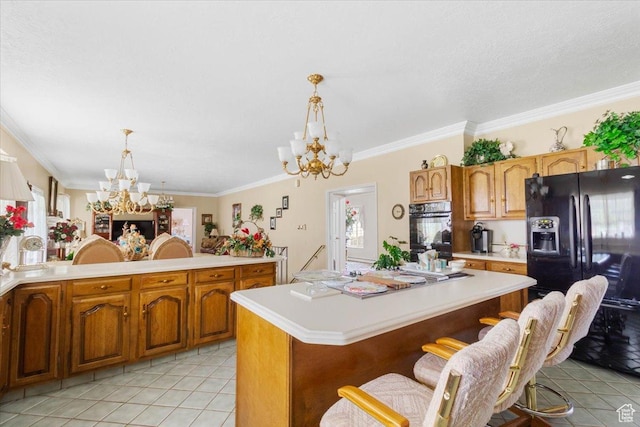 kitchen with black appliances, a breakfast bar, a center island, and hanging light fixtures