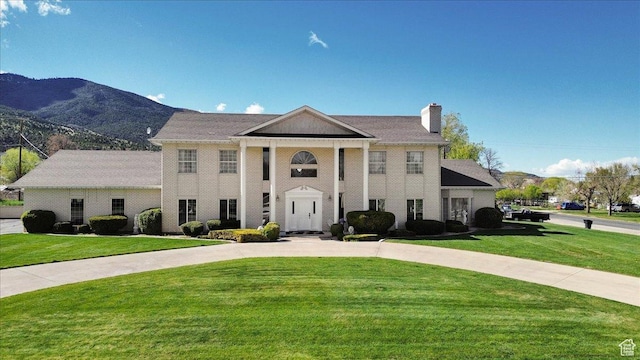 greek revival inspired property with a mountain view and a front yard