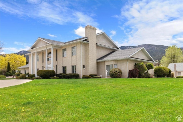 neoclassical / greek revival house with a mountain view and a front lawn