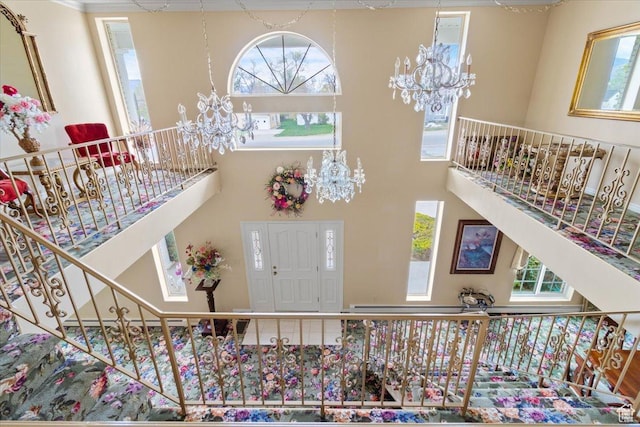interior space featuring a wealth of natural light, a towering ceiling, and an inviting chandelier