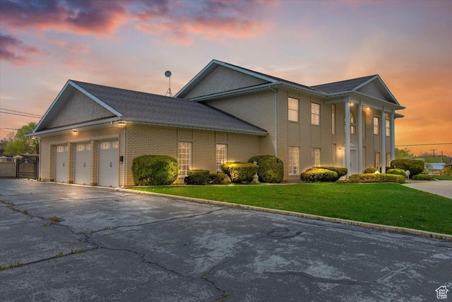 view of front of property with a garage and a lawn