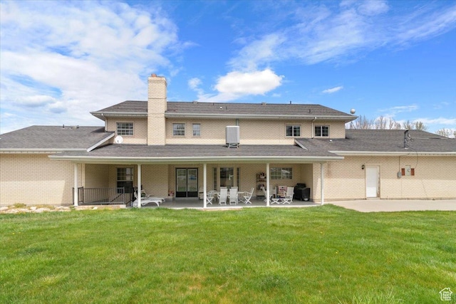 back of house featuring a lawn and a patio