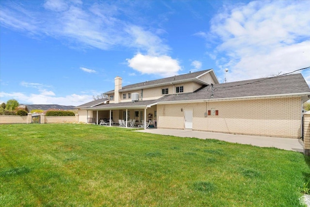 back of property with a yard and a patio area