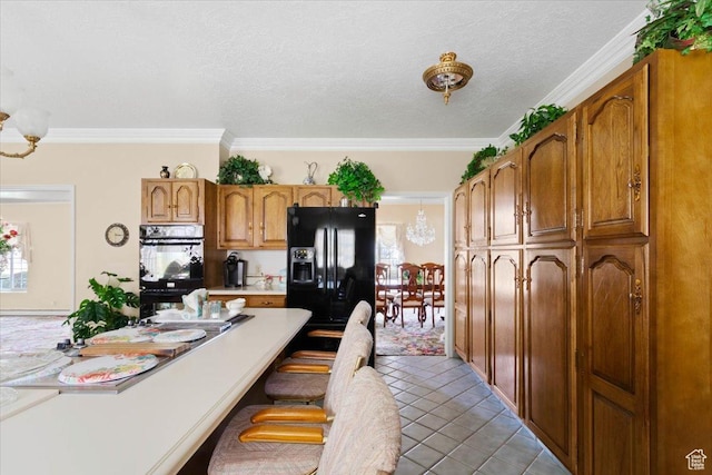 kitchen with plenty of natural light, light tile patterned floors, black appliances, and ornamental molding