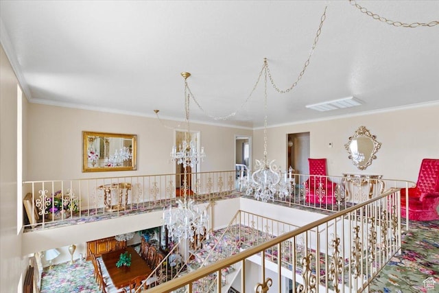 hallway featuring ornamental molding and an inviting chandelier