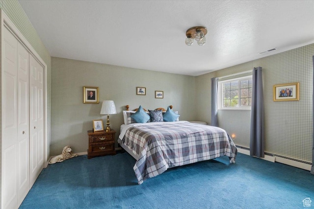 bedroom with dark colored carpet, baseboard heating, a textured ceiling, and a closet