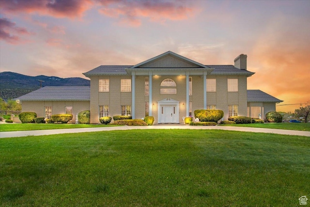 greek revival house featuring a mountain view and a yard