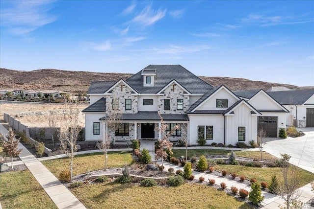 4009 S 2420 E, St George, UT 84790 - view of front of property featuring covered porch, concrete driveway, board and batten siding, a mountain view, and a front lawn